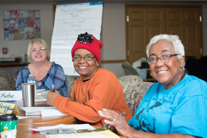 Three women in a class smiling