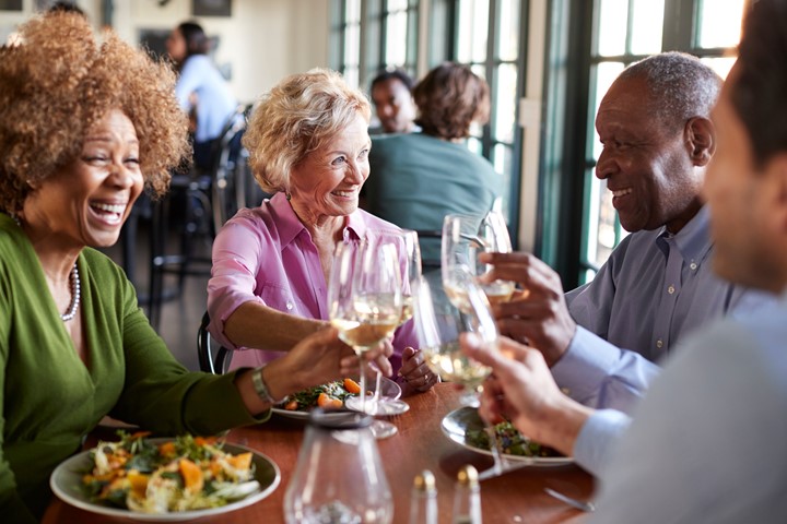 Group of older adults sitting at a table and eating.