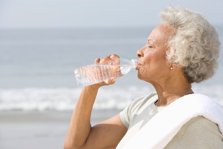 Older African American woman drinking water