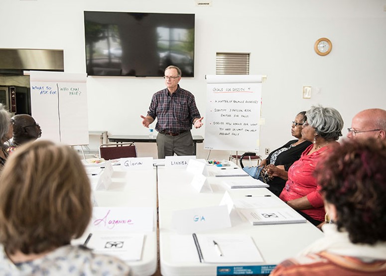 A Matter of Balance class with people gathered around a table and instructor in front