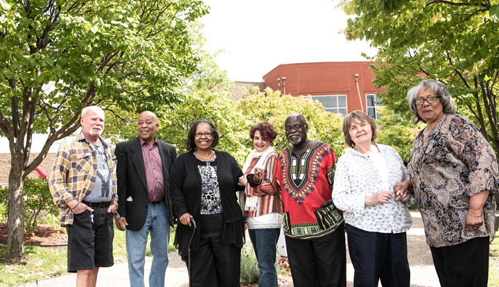 A group of older adults outside smiling.